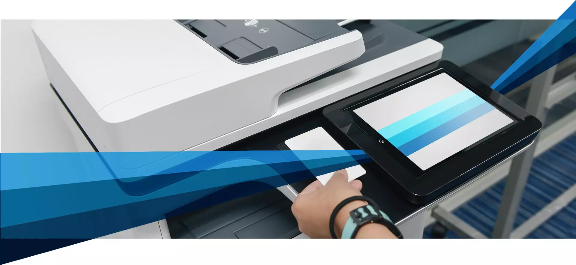 Personne utilisant une tablette tactile sur une imprimante multifonction.